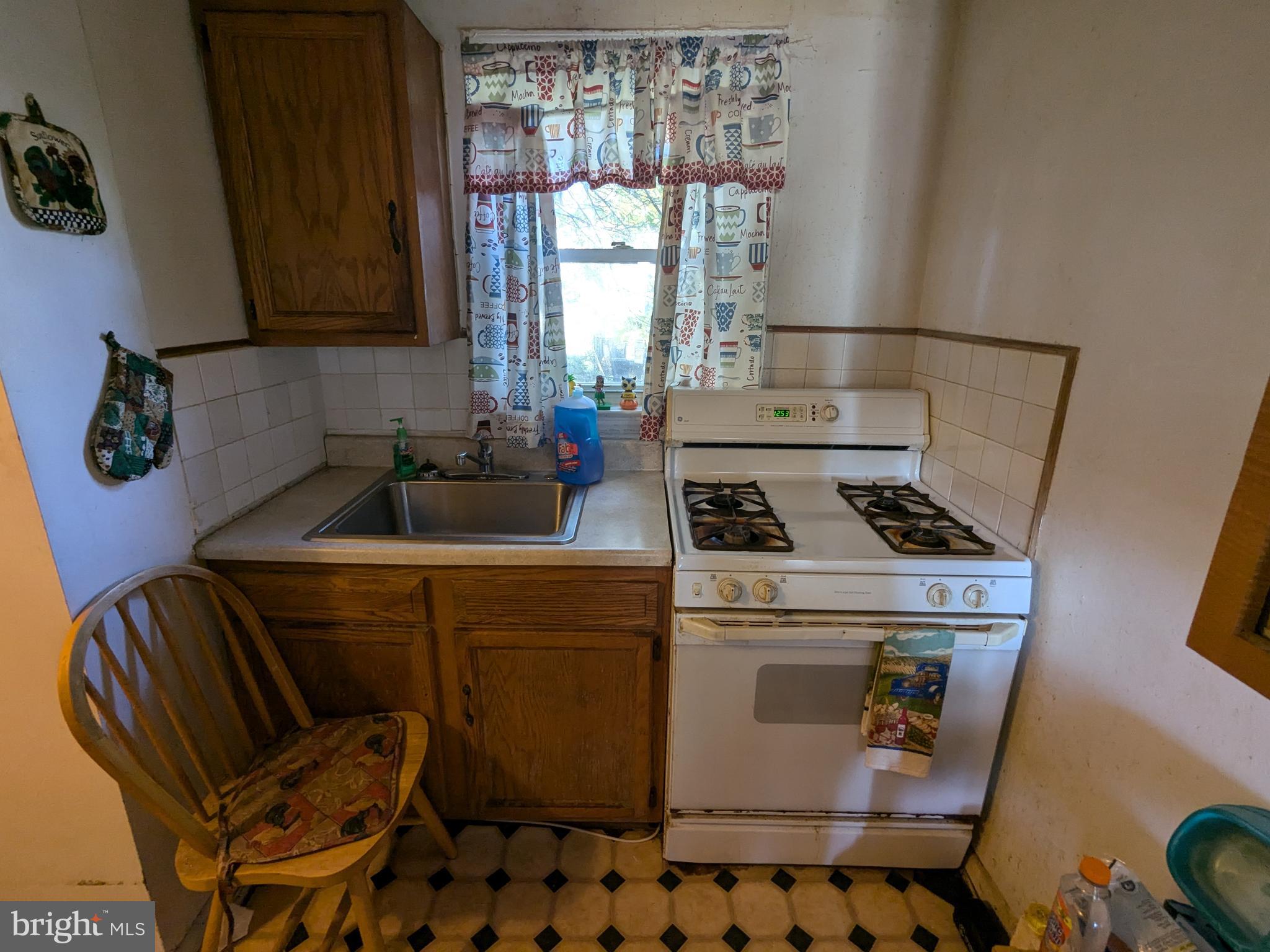 504 Bridgeview Road Baltimore, MD 21225 - Photo 5 of 12 a kitchen with a stove a sink and a microwave