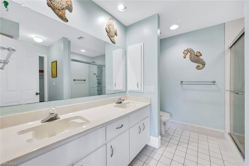 509 Roma Court, Unit 202 Naples, FL 34110 - Photo 11 of 18 Full bath with light tile patterned floors, a shower stall, double vanity, and recessed lighting