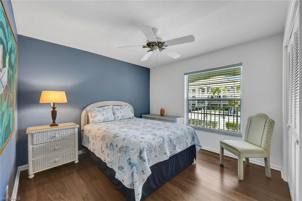 509 Roma Court, Unit 202 Naples, FL 34110 - Photo 12 of 18 Bedroom featuring dark wood-style flooring, ceiling fan, and a closet
