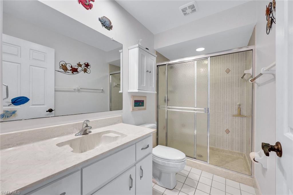509 Roma Court, Unit 202 Naples, FL 34110 - Photo 13 of 18 Bathroom with light tile patterned flooring, vanity, and a shower stall