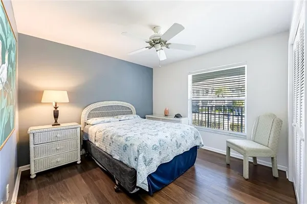 a bedroom with a bed wooden floor and a lamp