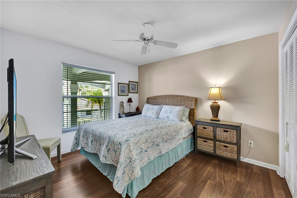 509 Roma Court, Unit 202 Naples, FL 34110 - Photo 14 of 18 Bedroom featuring dark wood-type flooring, a ceiling fan, and a closet