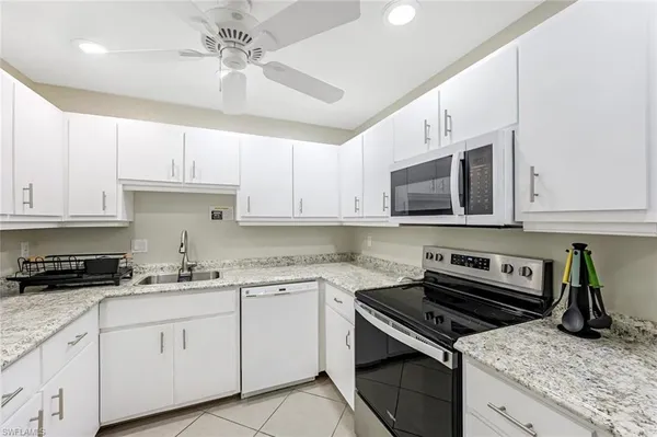 a kitchen with cabinets stainless steel appliances a sink and a counter space