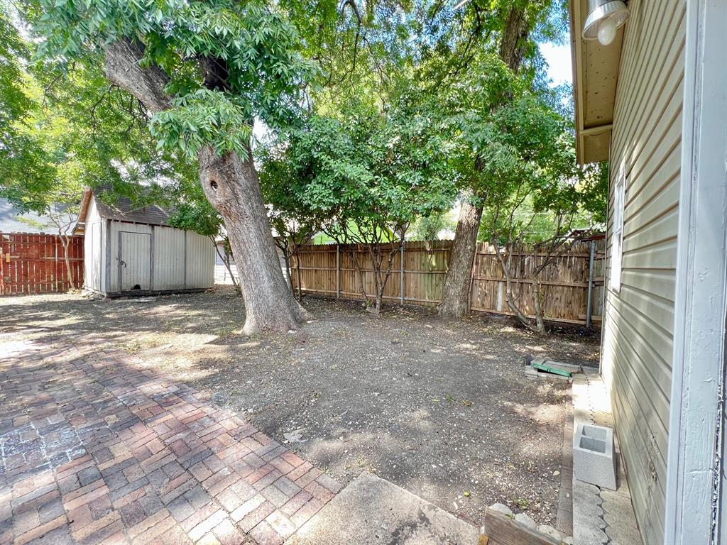 425 Grandview Avenue Dallas, TX 75223 - Photo 20 of 25 a view of a yard with a tree and wooden fence
