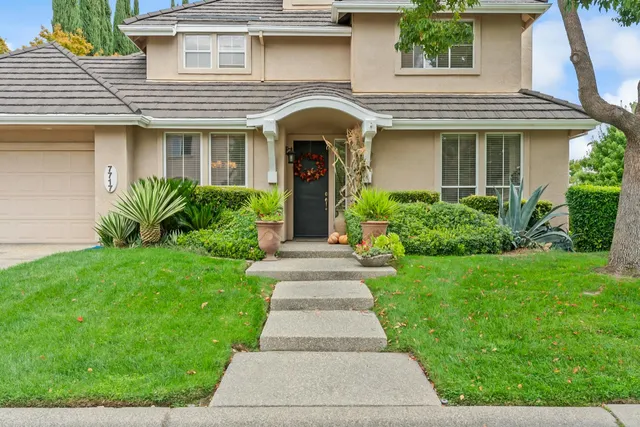 a front view of a house with potted plants