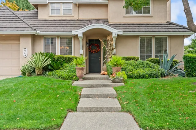 a front view of a house with potted plants