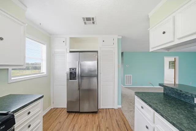 a kitchen with granite countertop a refrigerator and a sink