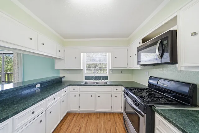 a kitchen with a sink stove top oven and cabinets