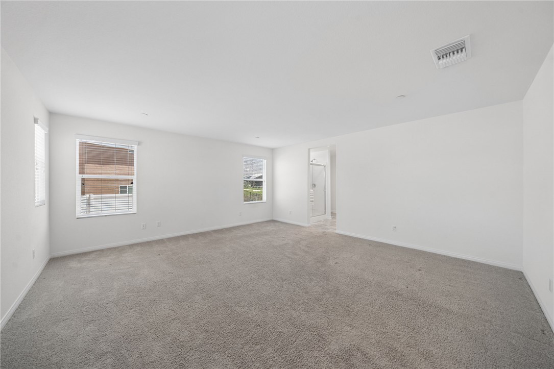 20130 Curaco Court Riverside, CA 92507 - Photo 23 of 43 Large primary bedroom with multiple windows and access to the bathroom.