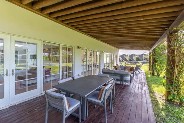 a view of a patio with table and chairs with wooden floor and fence with a barbeque grill