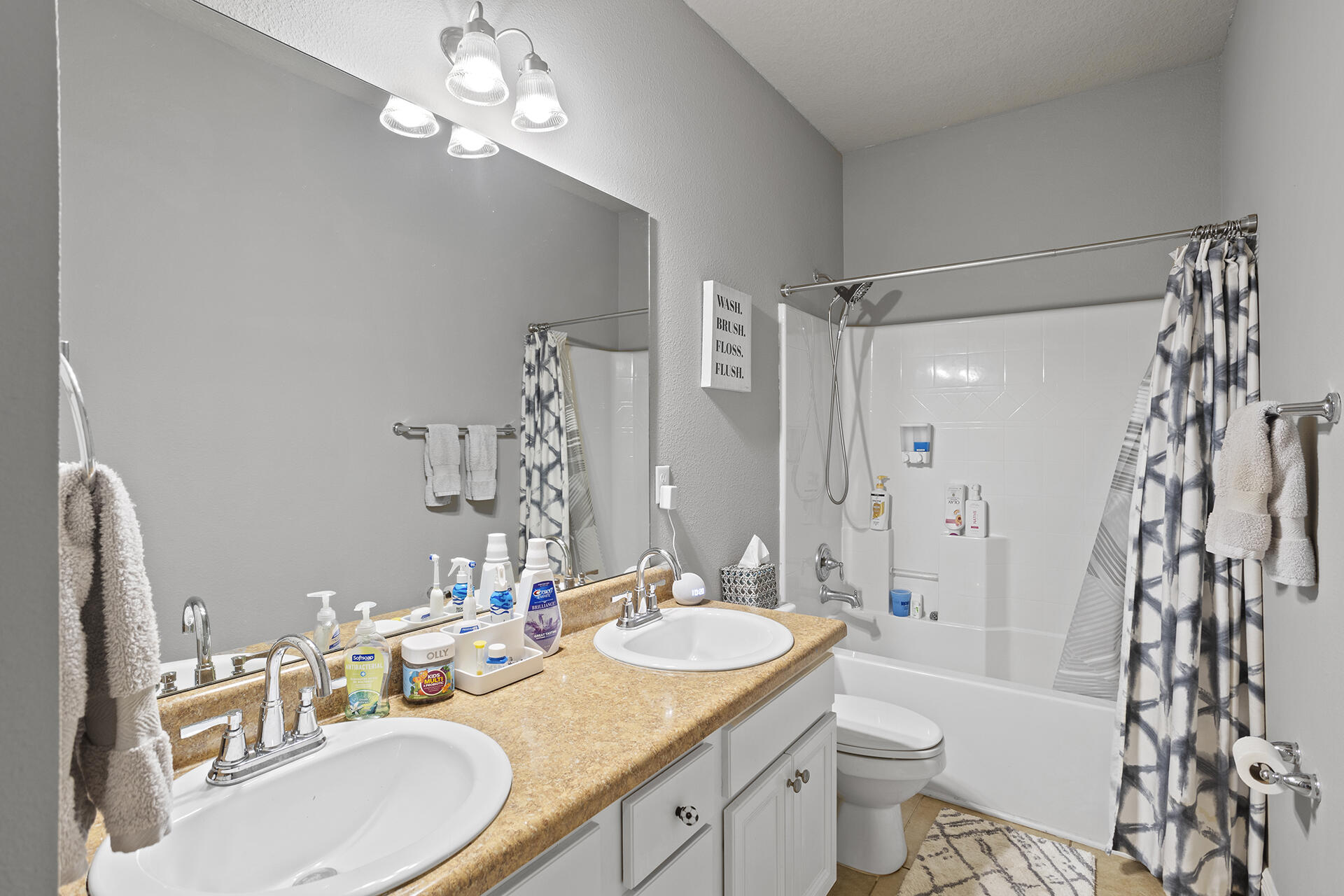 137 Old Ferry Road Santa Rosa Beach, FL 32459 - Photo 23 of 38 a bathroom with a granite countertop sink a toilet a mirror a vanity and shower