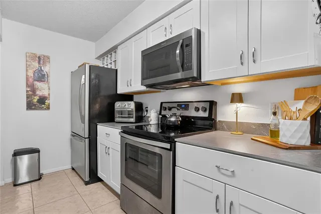 a kitchen with stainless steel appliances granite countertop a refrigerator stove and sink