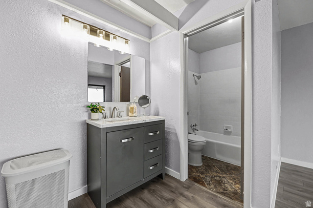 34 Benchmark Village Tooele, UT 84074 - Photo 16 of 35 Full bath with a textured wall, bathtub / shower combination, dark wood-type flooring, and vanity