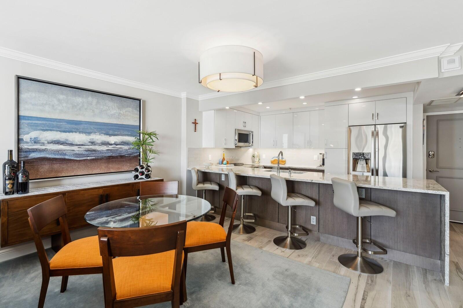 1900 South Ocean Boulevard, Unit 11B Lauderdale-by-the-Sea, FL 33062 - Photo 2 of 19 a kitchen with a dining table chairs stove and granite counter top