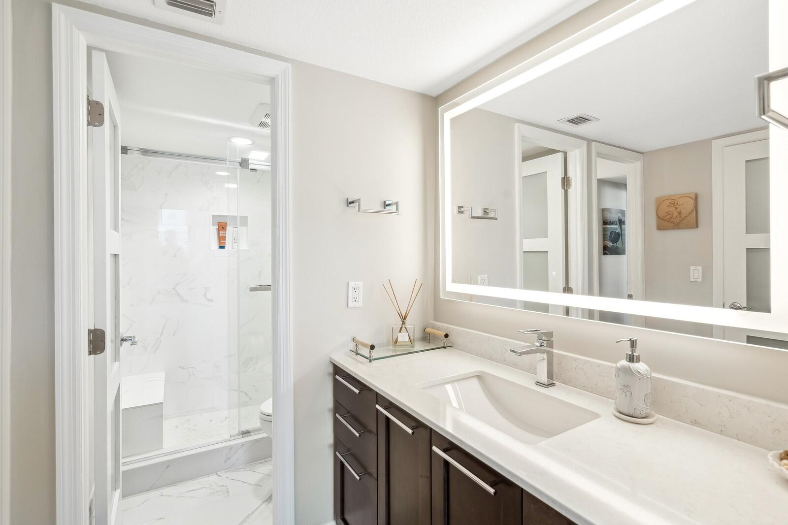 1900 South Ocean Boulevard, Unit 11B Lauderdale-by-the-Sea, FL 33062 - Photo 8 of 19 a bathroom with a double vanity sink mirror and shower