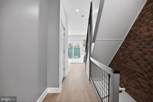 a view of a hallway with wooden floor and staircase
