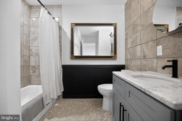 a bathroom with a granite countertop sink toilet and shower