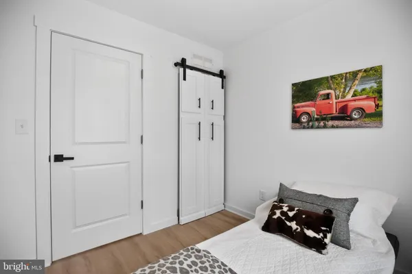 a bedroom with a bed and wooden floor