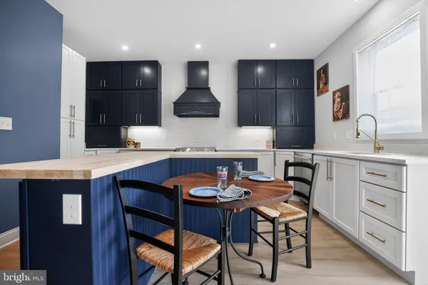 a kitchen with a sink a table and chairs in it