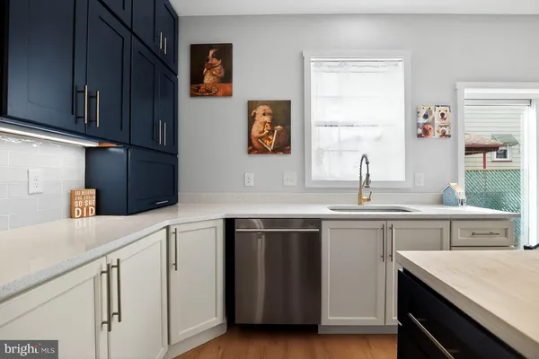a kitchen with stainless steel appliances granite countertop a sink and cabinets with wooden floor