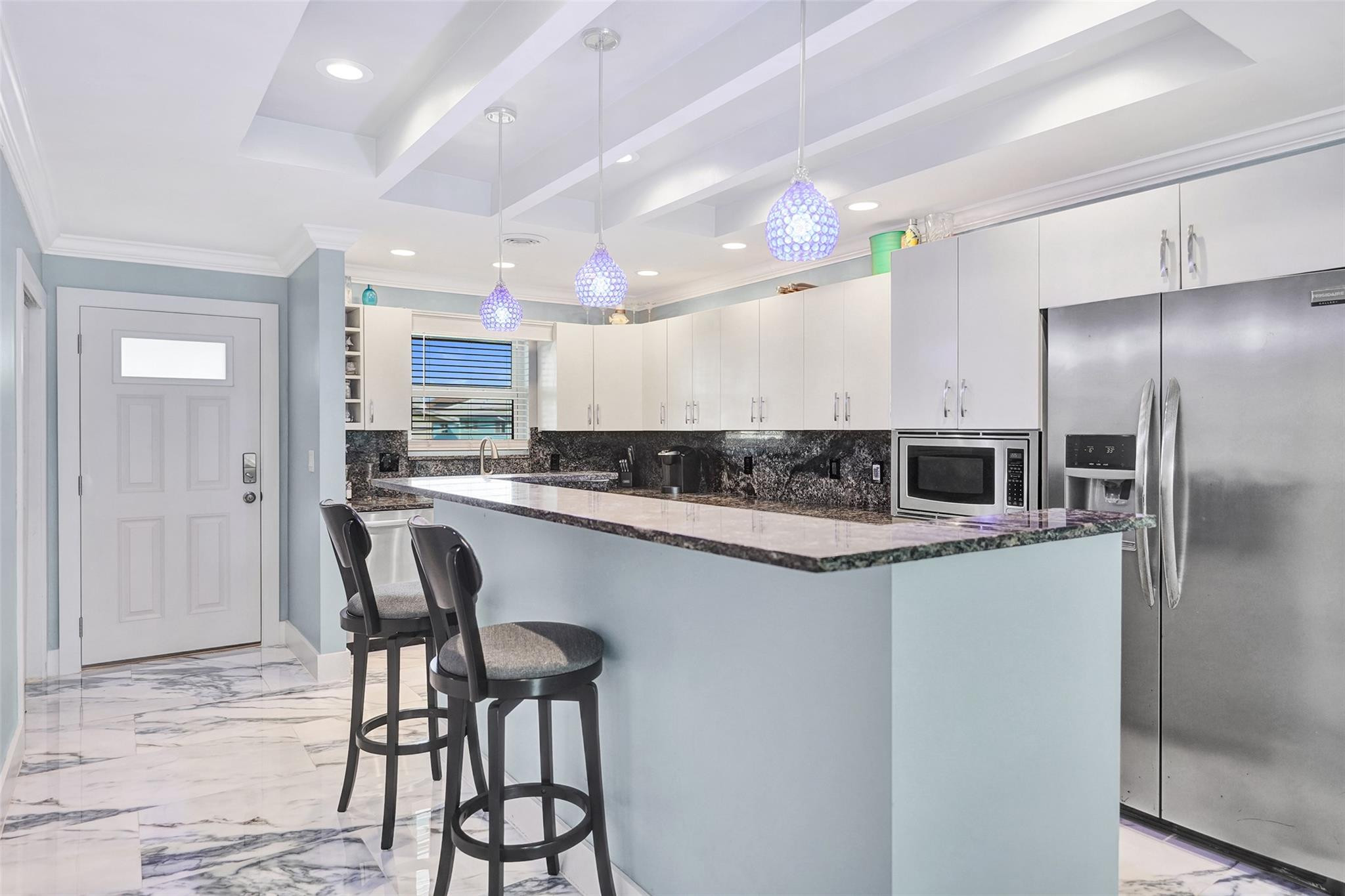 2330 Northeast 36th Street, Unit 9 Lighthouse Point, FL 33064 - Photo 11 of 48 a kitchen with kitchen island a counter top space a sink stainless steel appliances and cabinets