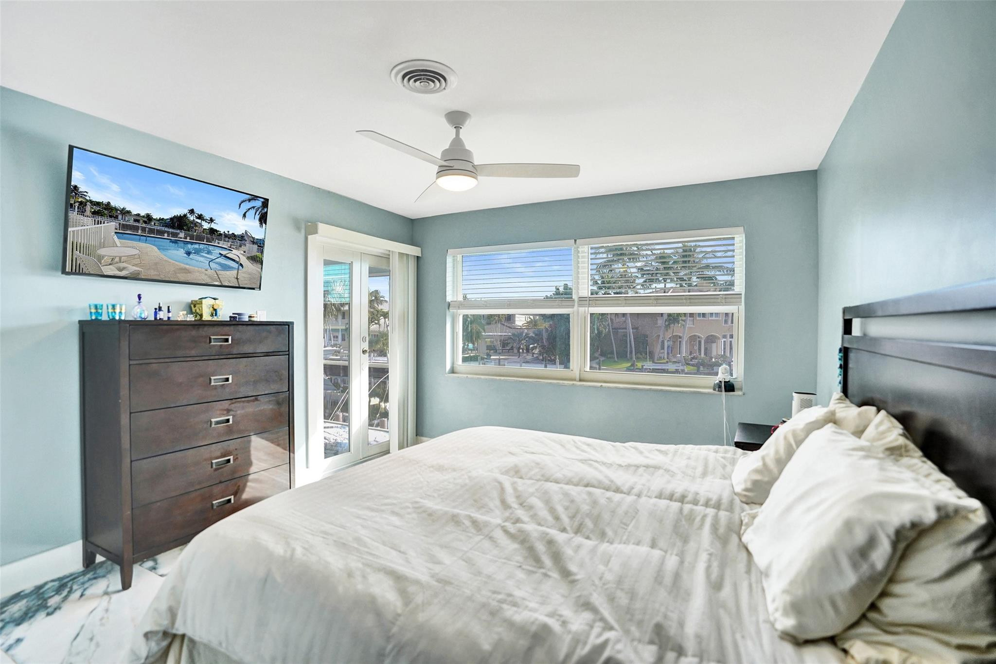 2330 Northeast 36th Street, Unit 9 Lighthouse Point, FL 33064 - Photo 29 of 48 a bedroom with a bed and wooden floor