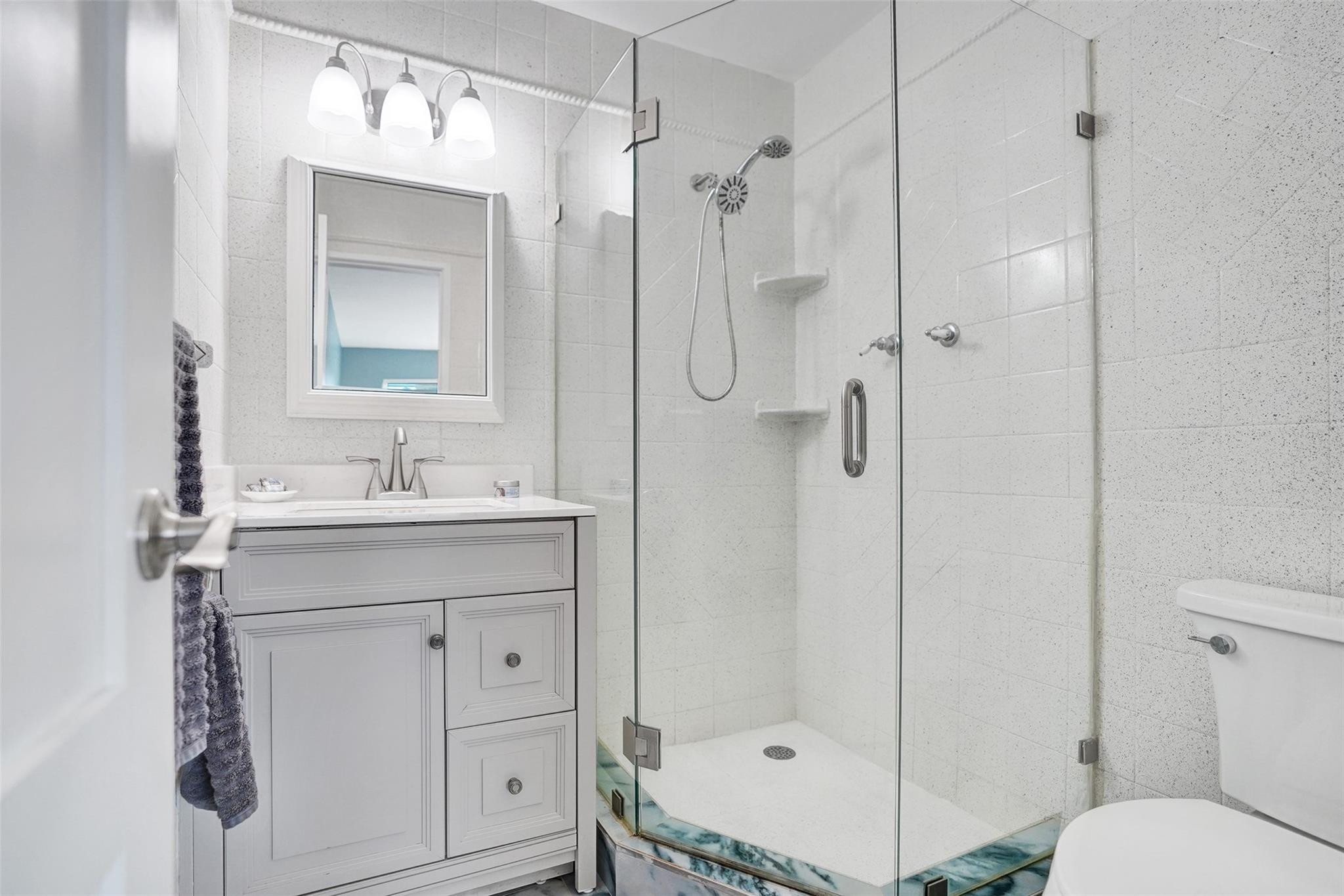 2330 Northeast 36th Street, Unit 9 Lighthouse Point, FL 33064 - Photo 34 of 48 a bathroom with a sink a toilet and shower