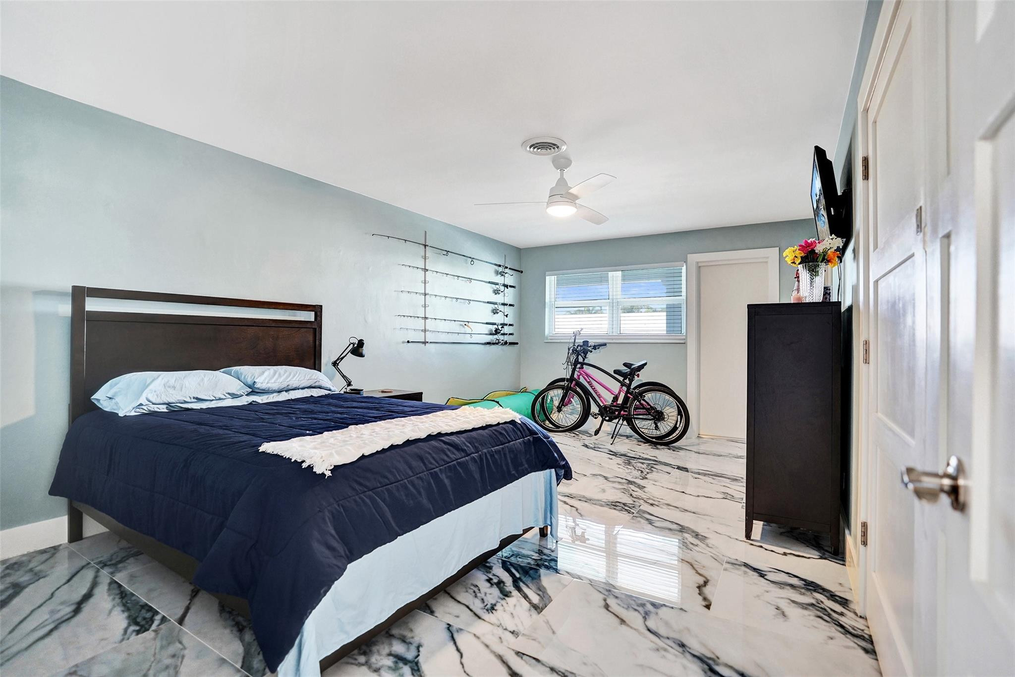2330 Northeast 36th Street, Unit 9 Lighthouse Point, FL 33064 - Photo 35 of 48 a bedroom with a bed and a flat tv screen on the dresser