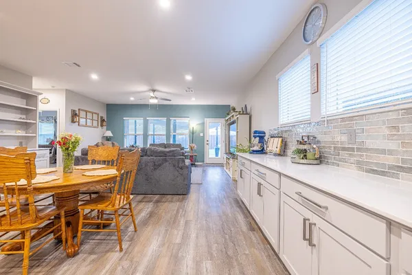 a large kitchen with stainless steel appliances granite countertop a lot of counter space and a dining table view