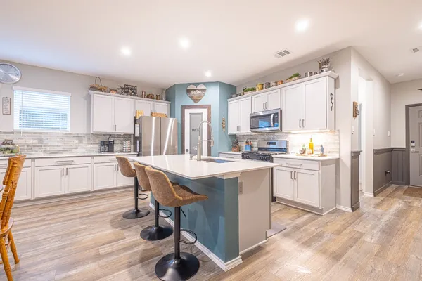 a kitchen with a sink a counter top space cabinets and stainless steel appliances