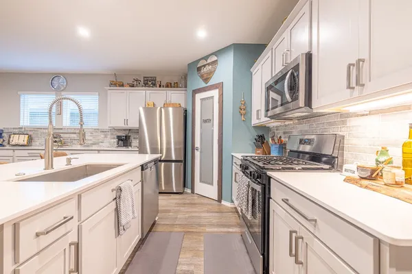 a kitchen with stainless steel appliances granite countertop a sink stove and refrigerator