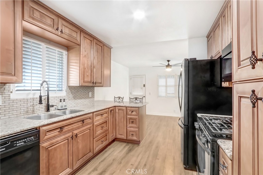 1277 West 14th Street Upland, CA 91786 - Photo 2 of 11 a kitchen with stainless steel appliances a refrigerator sink and cabinets