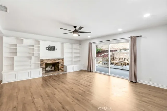 a view of an empty room with a fireplace and a window