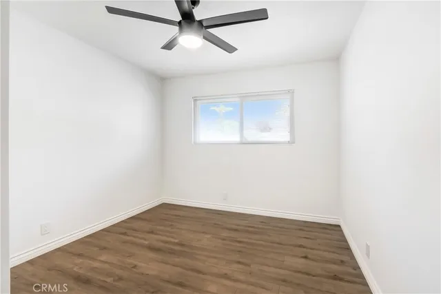 an empty room with a window and ceiling fan
