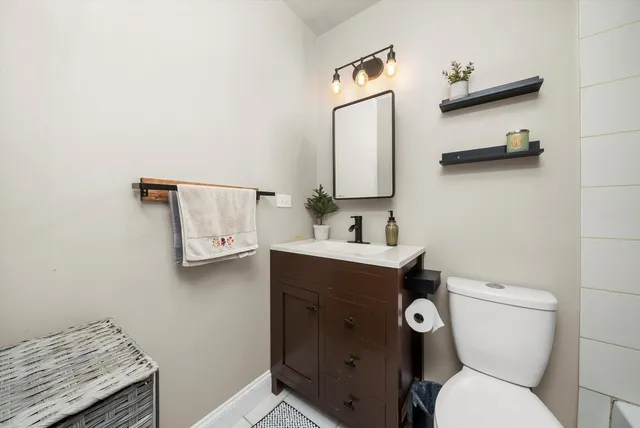 a bathroom with a toilet sink and mirror