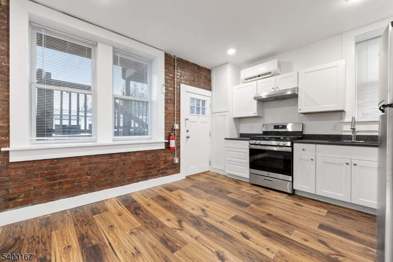 a kitchen with granite countertop a stove a sink and a refrigerator