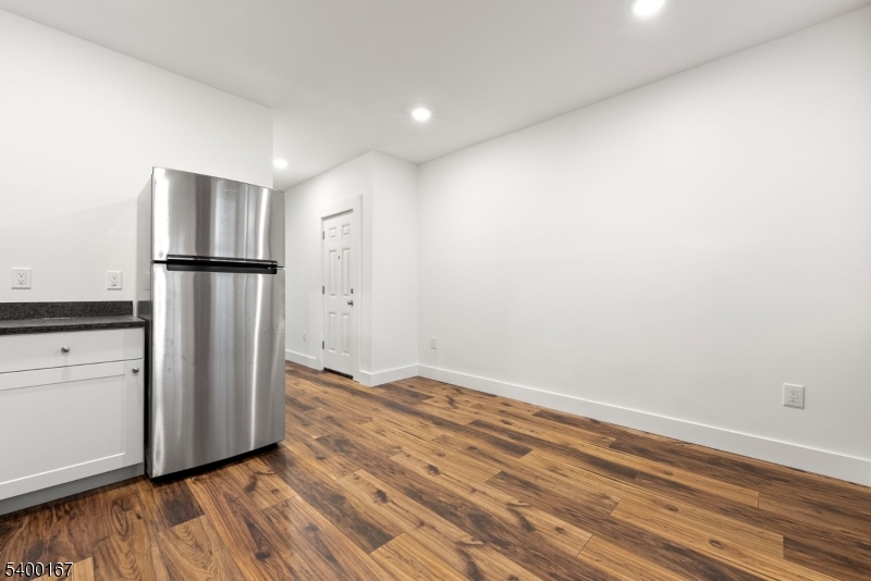 200 Forest Street, Unit R Montclair, NJ 07042 - Photo 3 of 13 a view of an empty room with wooden floor and a kitchen