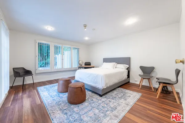 a bedroom with a bed and a large window