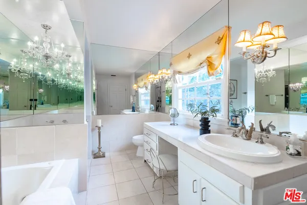 a bathroom with a sink a large mirror and a shower
