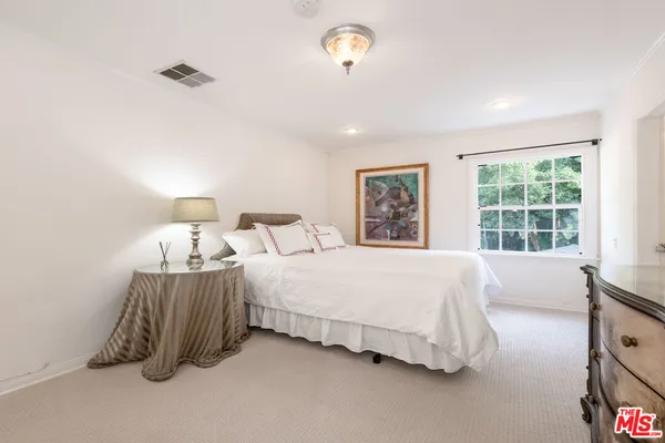 a spacious bedroom with two bed and a window