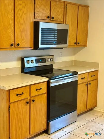 a stove top oven sitting inside of a kitchen