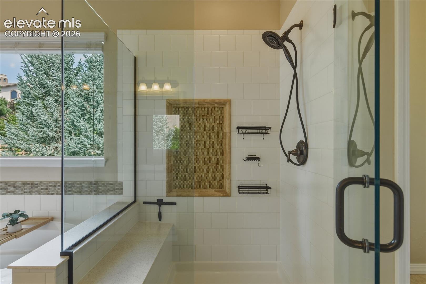 1118 Spectrum Loop Colorado Springs, CO 80921 - Photo 22 of 50 Glass-enclosed shower with a built-in bench, white subway tile surround, and oil-rubbed bronze fixtures
