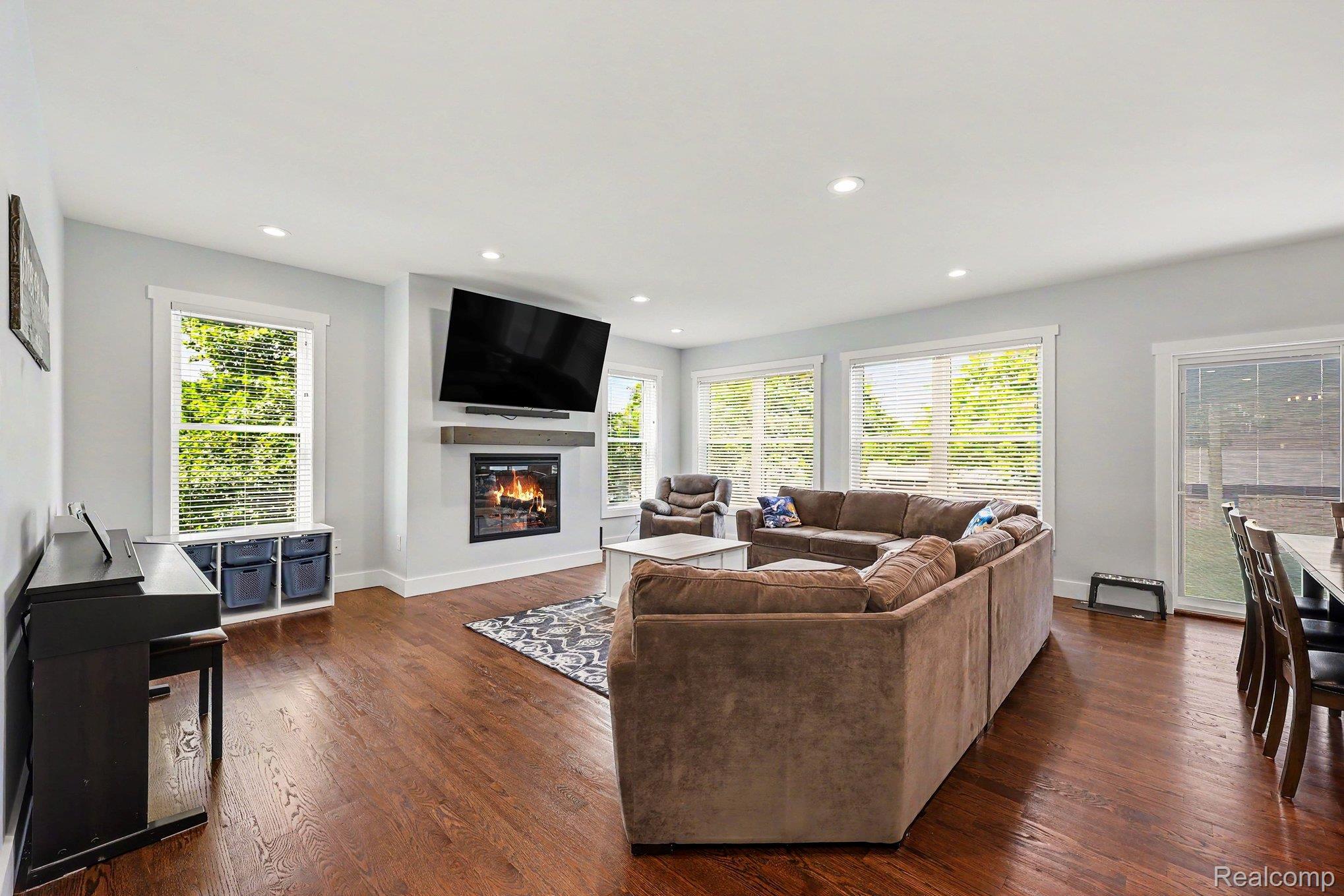 1660 Winthrop Road Bloomfield Hills, MI 48302 - Photo 9 of 38 Open-concept living space featuring wood-finish flooring, a built-in fireplace with a mantel, recessed lighting, and multiple windows