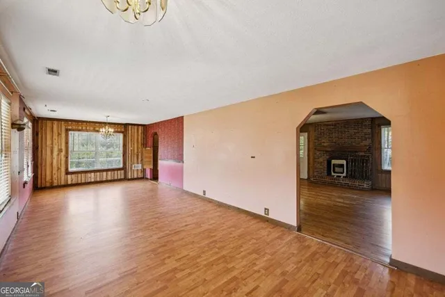 a view of a livingroom with wooden floor and a fireplace