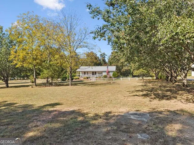 a front view of a house with a garden and trees