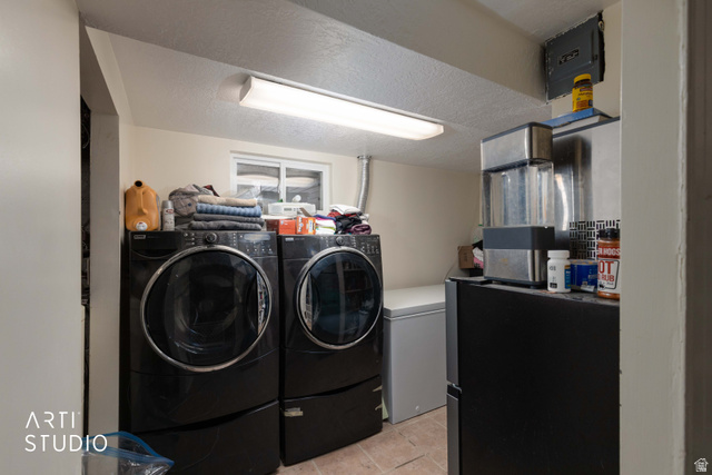 875 Patterson Street Ogden, UT 84403 - Photo 20 of 38 Laundry area with a textured ceiling, washer and dryer, and light tile patterned floors