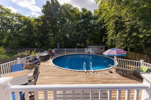 a view of a swimming pool with a patio and a yard