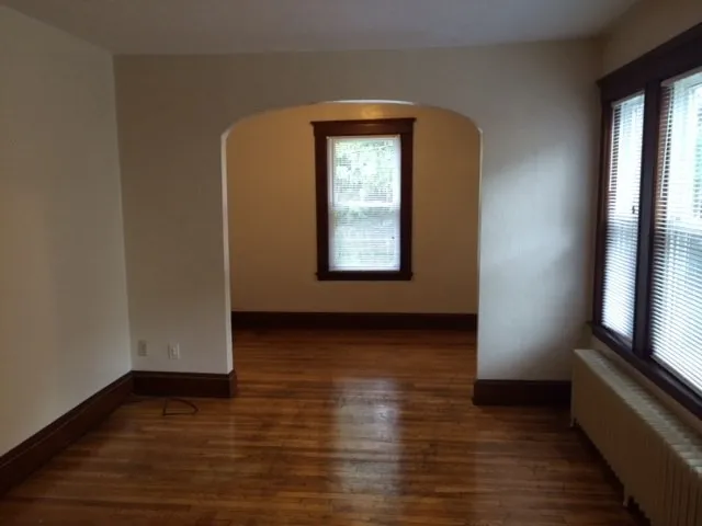 a view of a room with wooden floor and a window