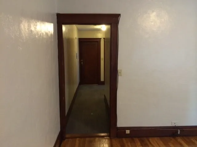 a view of a hallway with wooden floor