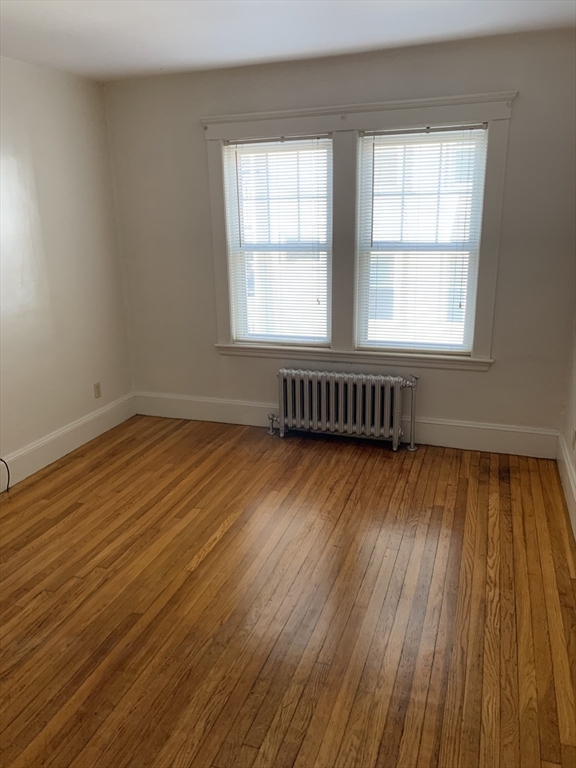 20 Prospect Avenue, Unit 8 Quincy, MA 02170 - Photo 5 of 13 an empty room with wooden floor and windows